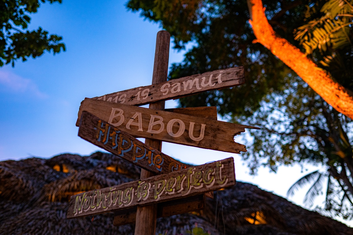 A handmade signpost reading "This is Samui, BABOU" at dusk