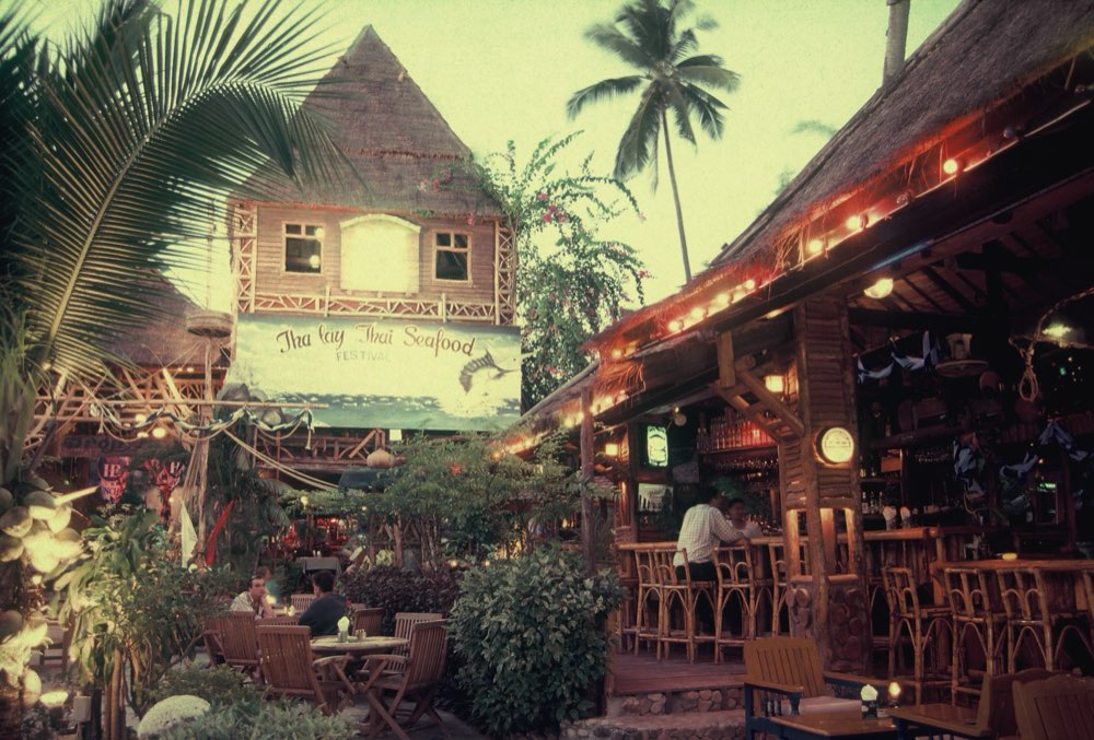 The Drop In bar and thatched pavilions at dusk