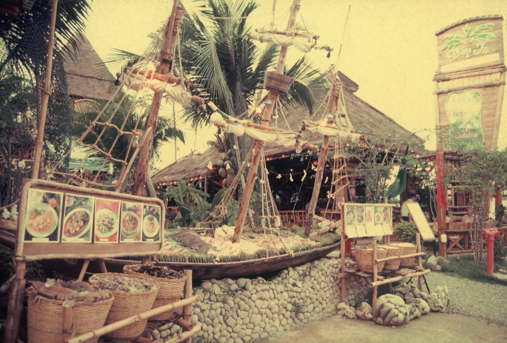 The boat-shaped fresh seafood display beneath the Drop In Cuisine sign