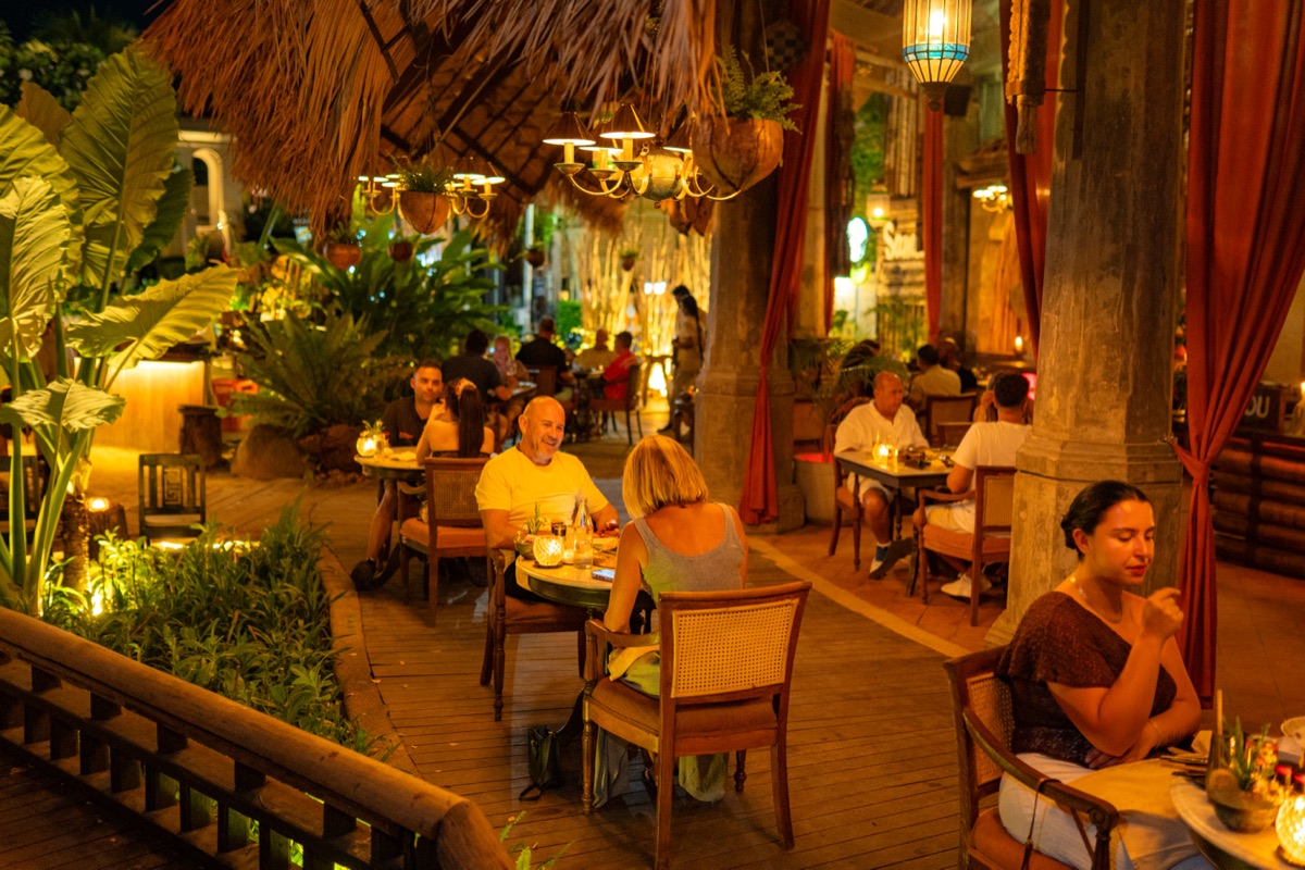 Guests dining together on BABOU's terrace at night