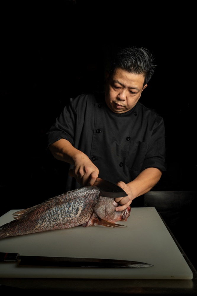 BABOU's chef preparing a whole fish for the Raw Bar