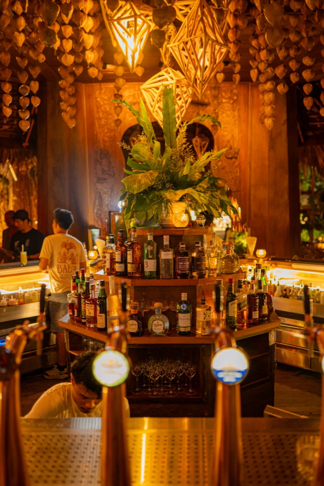 BABOU's bar, shelves of spirits under woven pendant lights